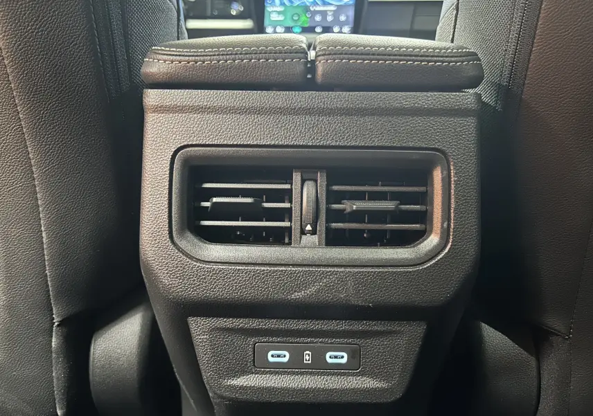 Gros plan sur la sortie d’air arrière noire et les deux ports USB-C du Renault Austral blanc nacré, intérieur cuir noir.
