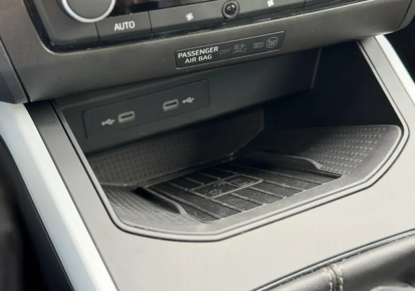 Gros plan sur la console centrale du SEAT Arona TSI 115 Style 2025, montrant les ports USB et le rangement antidérapant noir.