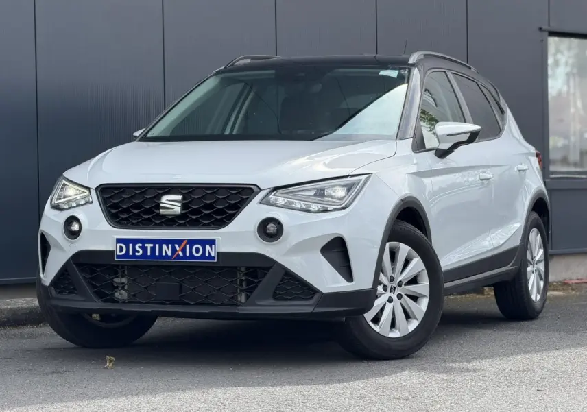 Vue 3/4 avant d'un SEAT Arona blanc alpin avec toit noir, calandre noire et jantes alliage 16 pouces.