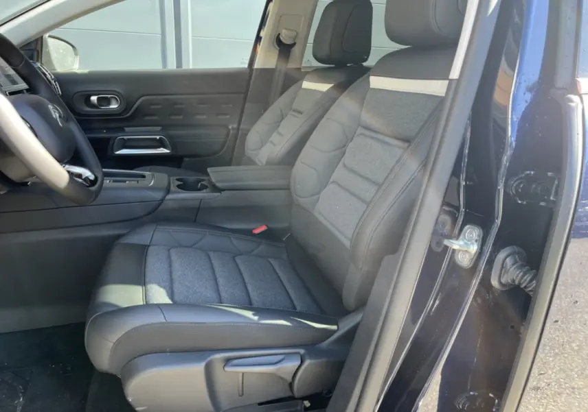 Vue intérieure côté conducteur du Citroën C5 Aircross bleu eclipse, mettant en valeur les sièges advanced comfort et l'accoudoir central.