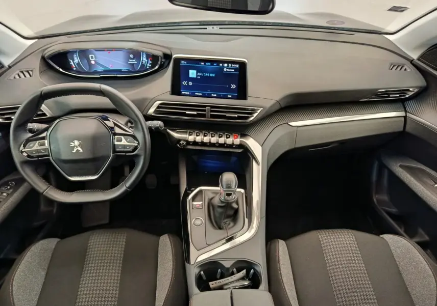 Vue intérieure frontale du tableau de bord et volant cuir du Peugeot 3008 gris foncé avec écran tactile central.