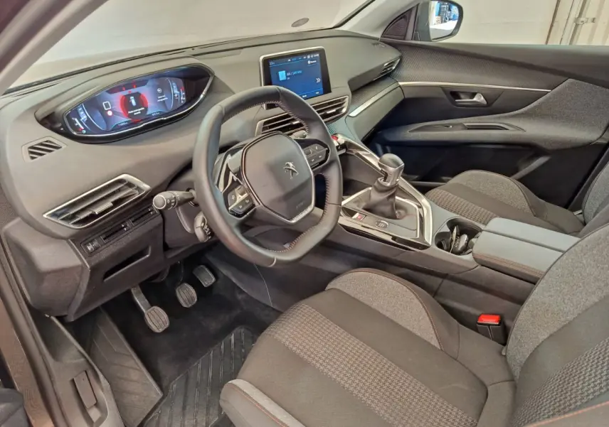 Intérieur côté conducteur du Peugeot 3008 gris foncé, avec tableau de bord numérique et écran tactile central.