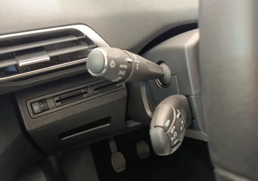 Gros plan sur les commandes de phares et essuie-glaces à gauche du volant du Peugeot 3008 gris foncé, version 2020.