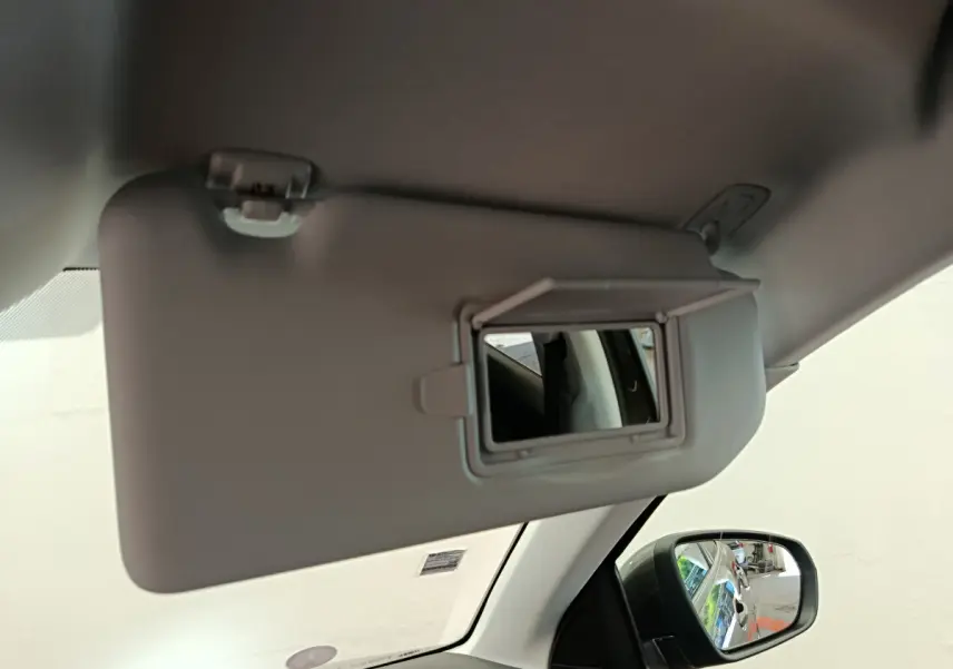 Miroir de courtoisie ouvert sur le pare-soleil côté gauche dans l’habitacle gris clair du Peugeot 3008 2020.