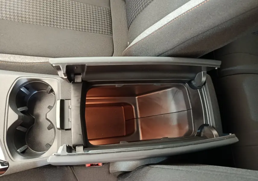 Vue plongeante sur le rangement central ouvert et les porte-gobelets du Peugeot 3008 gris foncé, intérieur tissu.