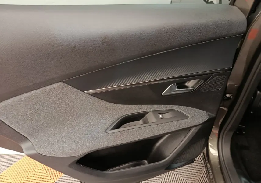 Vue rapprochée de la porte arrière droite gris foncé du Peugeot 3008 2020 avec habillage tissu et plastique noir.