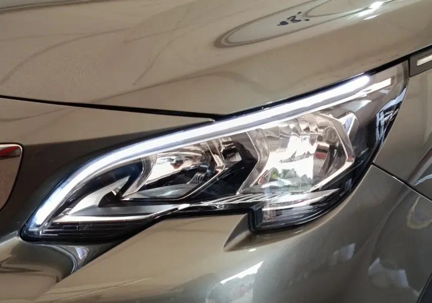 Gros plan sur le phare avant droit du Peugeot 3008 gris foncé, mettant en valeur son design LED distinctif.