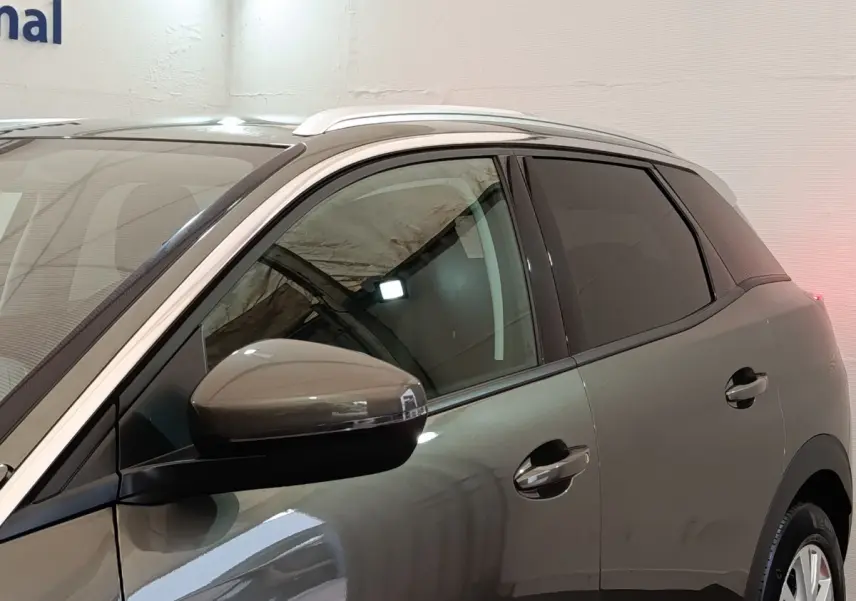 Profil côté gauche du Peugeot 3008 gris foncé 2020, mettant en valeur les vitres teintées et les rétroviseurs intégrant les clignotants.