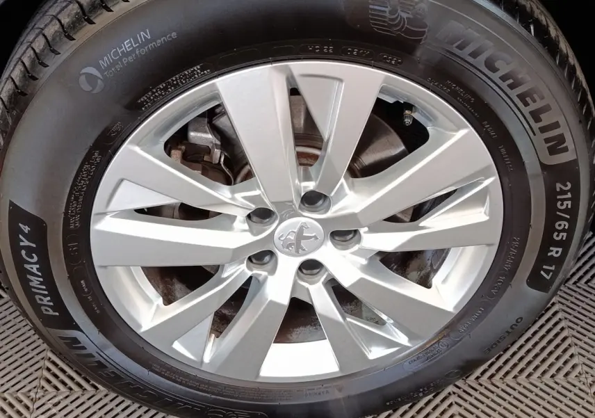 Gros plan sur la jante argentée et le pneu Michelin du Peugeot 3008 gris foncé, version Puretech 130 S&S Active Business.