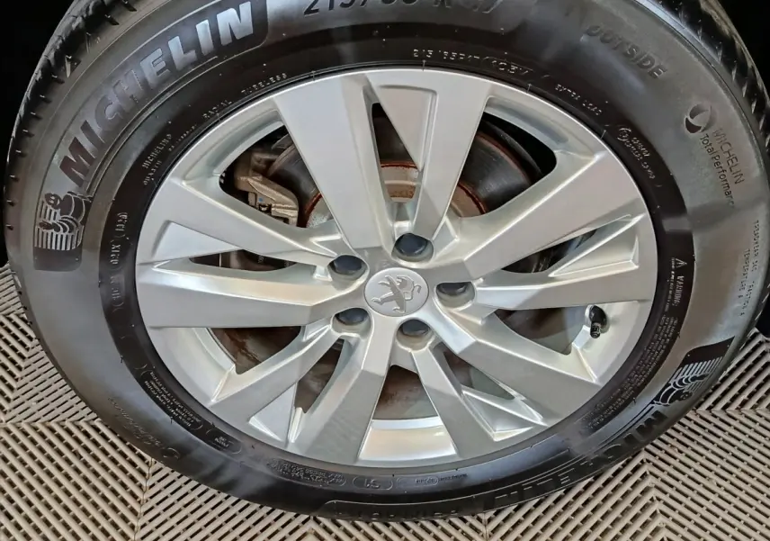Gros plan sur la jante alliage argentée et pneu Michelin du Peugeot 3008 gris foncé de 2020.