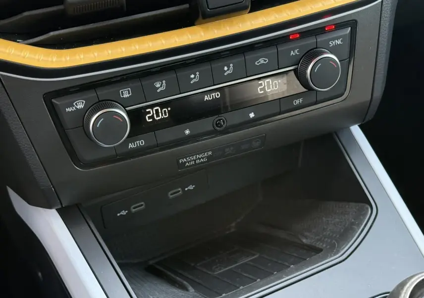 Détail de la console centrale du SEAT Arona 2025 avec commandes de climatisation bi-zone et ports USB visibles.