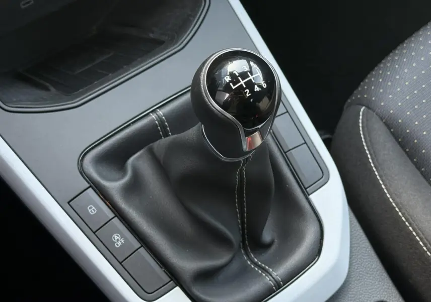 Gros plan sur le levier de vitesses manuel noir avec coutures blanches dans l’habitacle du SEAT Arona TSI 115 Style 2025.