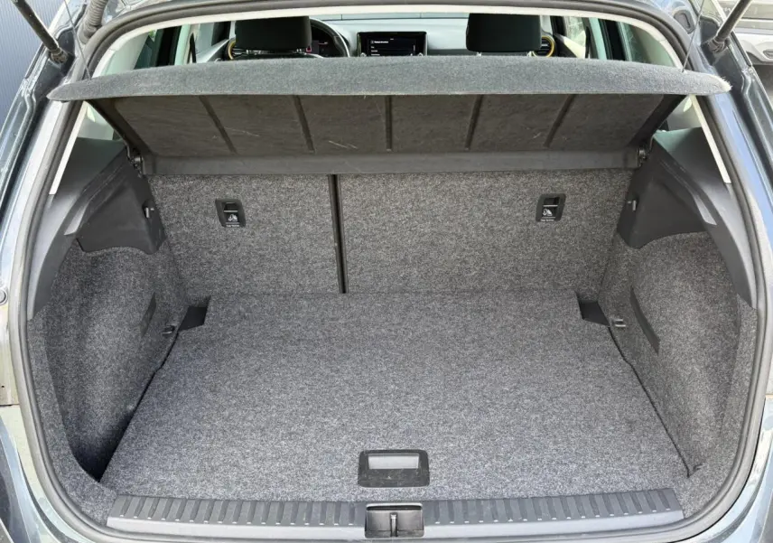 Coffre ouvert vu de l'arrière d'un SEAT Arona gris magnétique, montrant l'espace de rangement et la tablette cache-bagages.