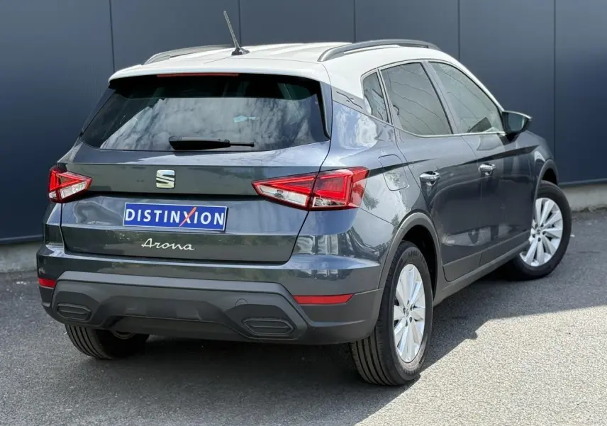Vue 3/4 arrière droite du SEAT Arona 2025 gris magnétique avec toit blanc et vitres arrière surteintées.
