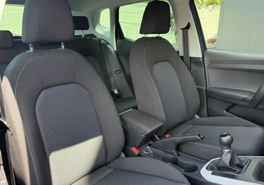 Vue intérieure des sièges avant noirs et console centrale avec levier de vitesse manuelle d'une SEAT Arona 2025.