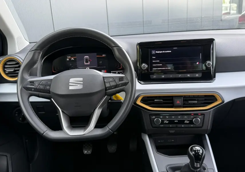 Intérieur SEAT Arona TSI 115 Style 2025 vu de face, volant multifonction, écran tactile et détails bois clair.