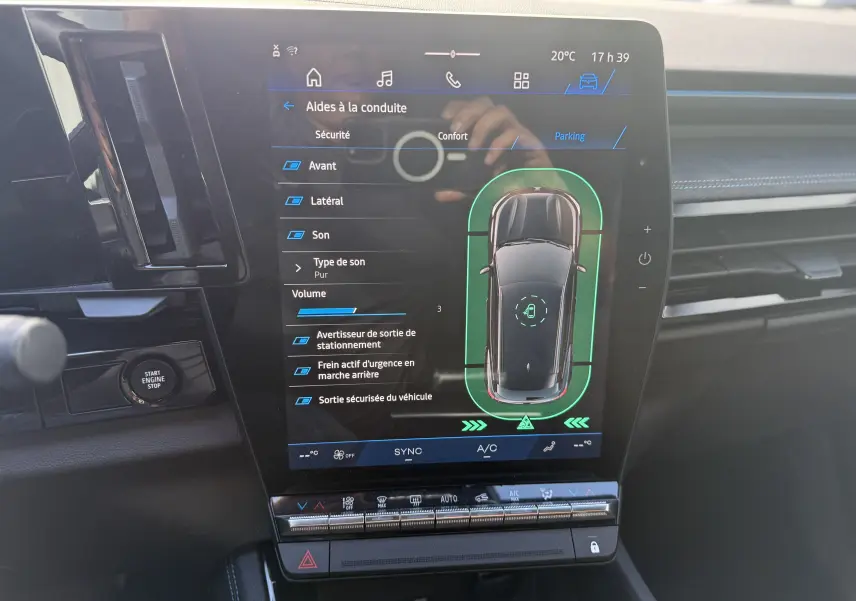 Vue rapprochée de l’écran tactile central du Renault Austral Hybrid blanc nacré, affichant les aides à la conduite.