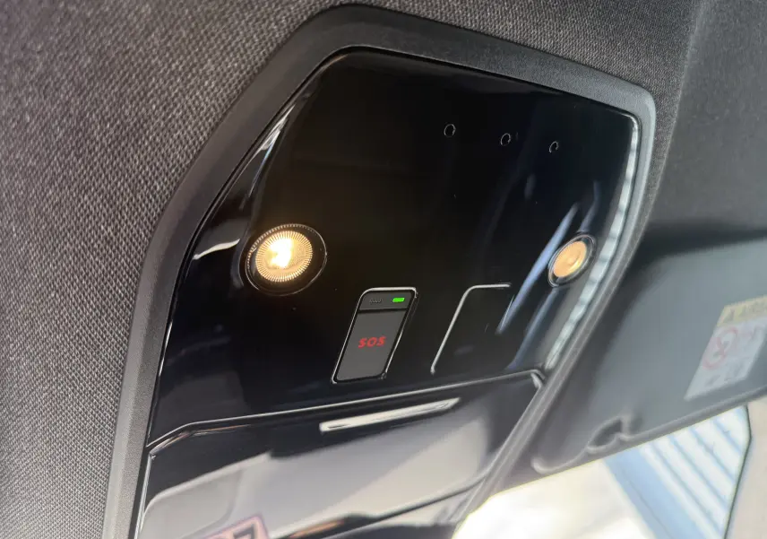 Vue intérieure en gros plan du plafonnier noir brillant avec éclairages et bouton SOS du Renault Austral blanc nacré 2025.