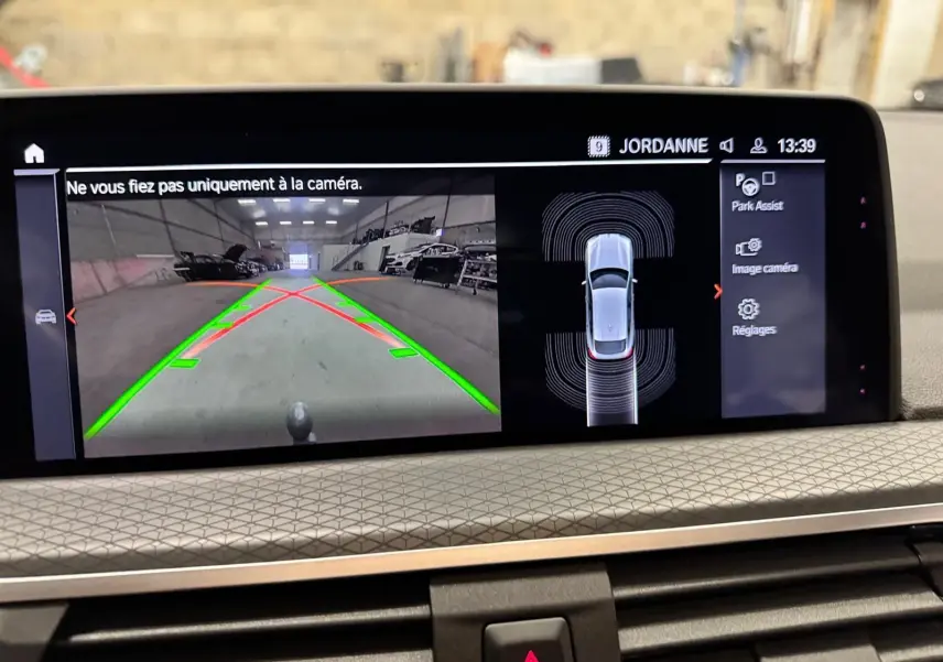 Écran intérieur de BMW X4 XDrive 20d 2020 montrant la caméra de recul et l'assistance au stationnement.