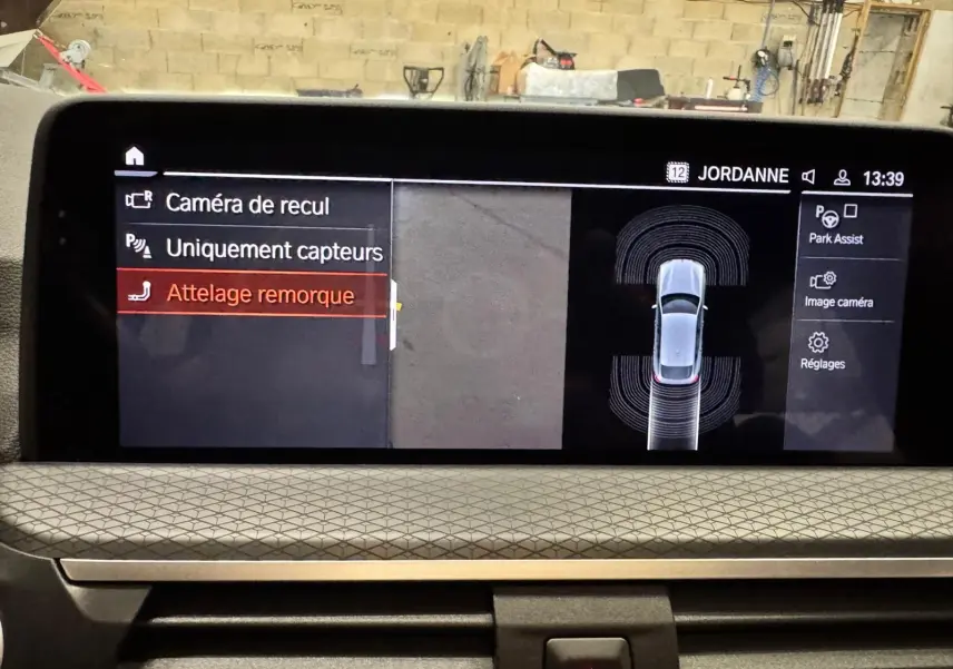 Écran multimédia du BMW X4 XDrive 20d 2020 affichant l'option attelage remorque en vue intérieure tableau de bord.