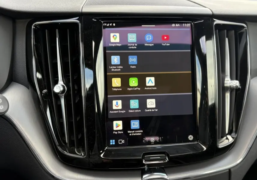 Écran tactile central du tableau de bord du Volvo XC60 2024, entouré de sorties d'air verticales noires et argentées.