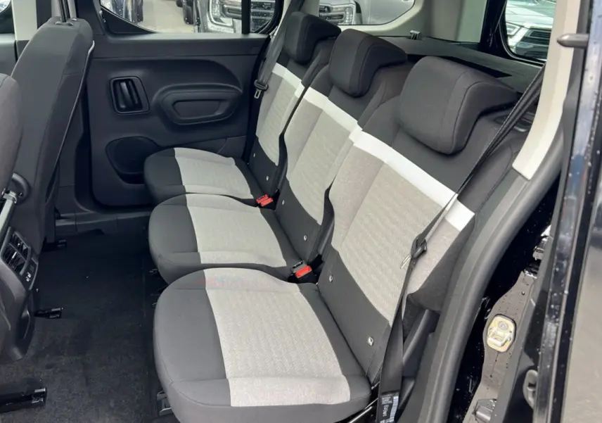 Vue latérale droite de l'intérieur arrière du Citroën Berlingo 2025 noir perla nera avec sièges tissu bicolore gris et noir.