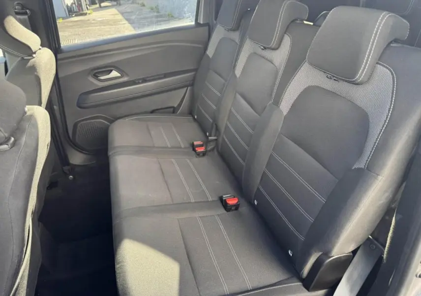 Vue intérieure côté droit sur la banquette arrière noire du Dacia Jogger 2025 avec appuie-têtes et ceintures visibles.
