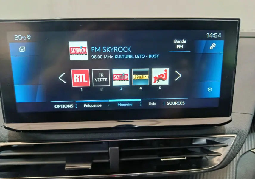 Écran tactile central 10 pouces du tableau de bord du Peugeot 3008 bleu, affichant les radios FM en intérieur.