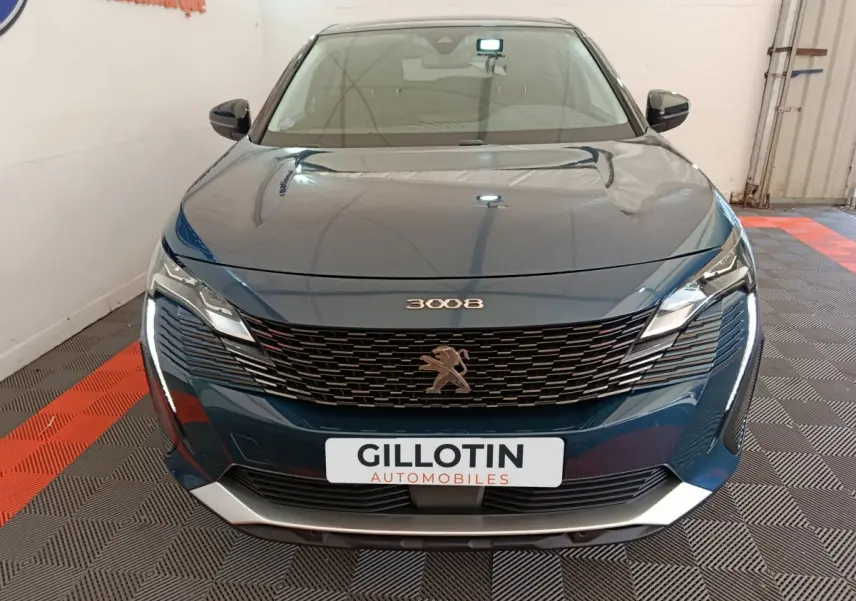 Vue frontale d'un Peugeot 3008 bleu 2022 avec calandre noire et feux LED distinctifs allumés.