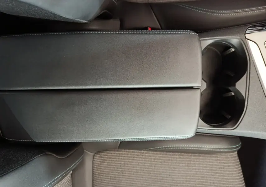 Vue rapprochée de l'accoudoir central noir et des porte-gobelets du Peugeot 3008 PureTech 130 S&S Allure 2022.