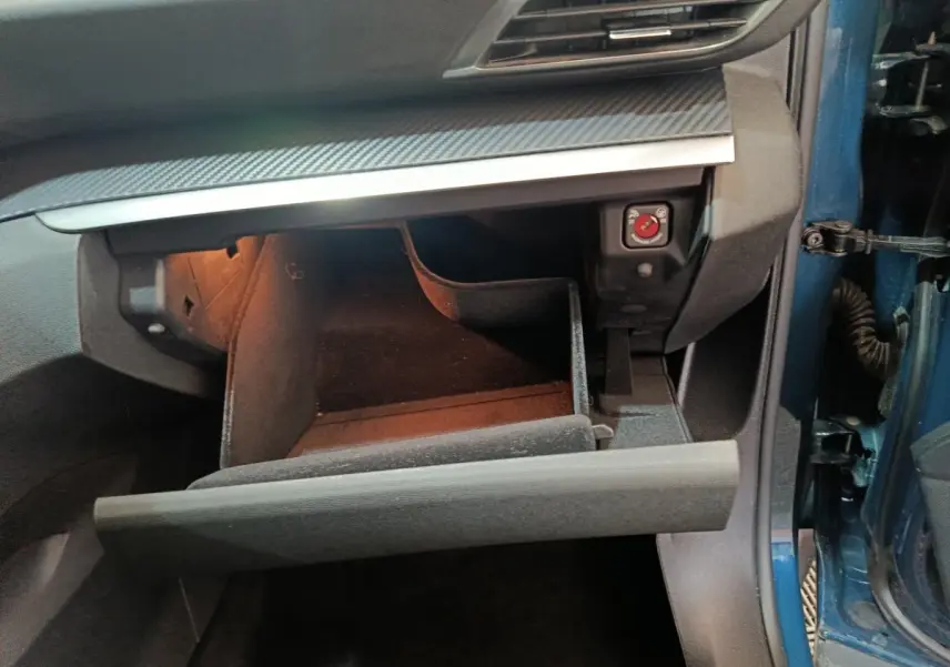 Gant de boîte à gants ouvert côté passager d’un Peugeot 3008 bleu 2022, intérieur noir avec éclairage intérieur.