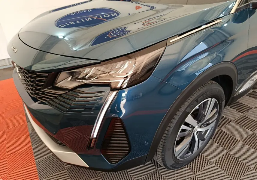 Vue 3/4 avant droit du Peugeot 3008 bleu mettant en valeur ses phares LED et la calandre distinctive.