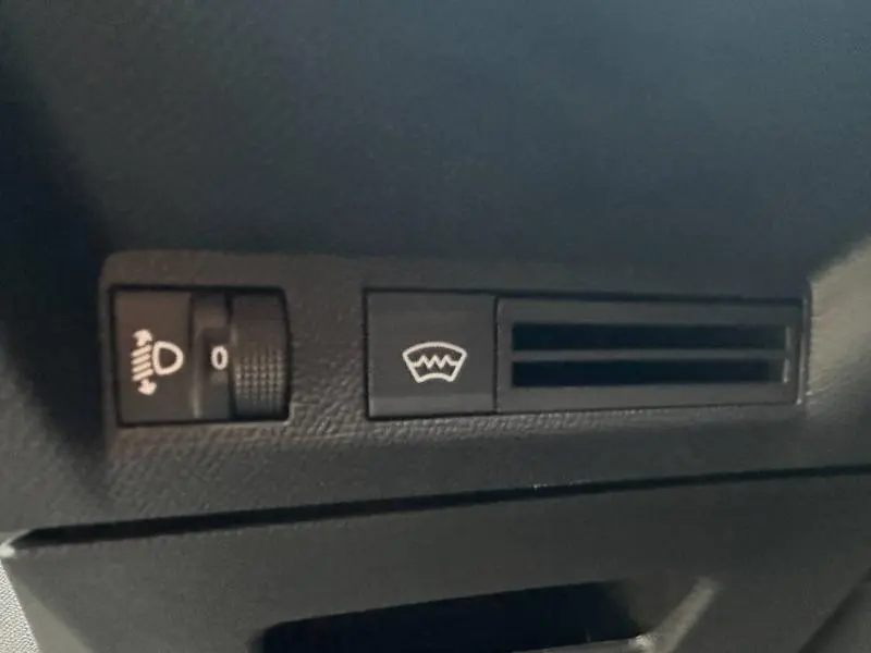 Détail du tableau de bord noir du Peugeot 3008 2025 montrant les commandes de réglage des phares et du dégivrage avant.