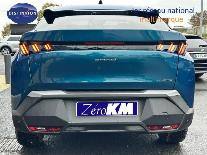 Vue arrière d'un Peugeot 3008 bleu avec feux LED allumés et becquet arrière visible sur parking.