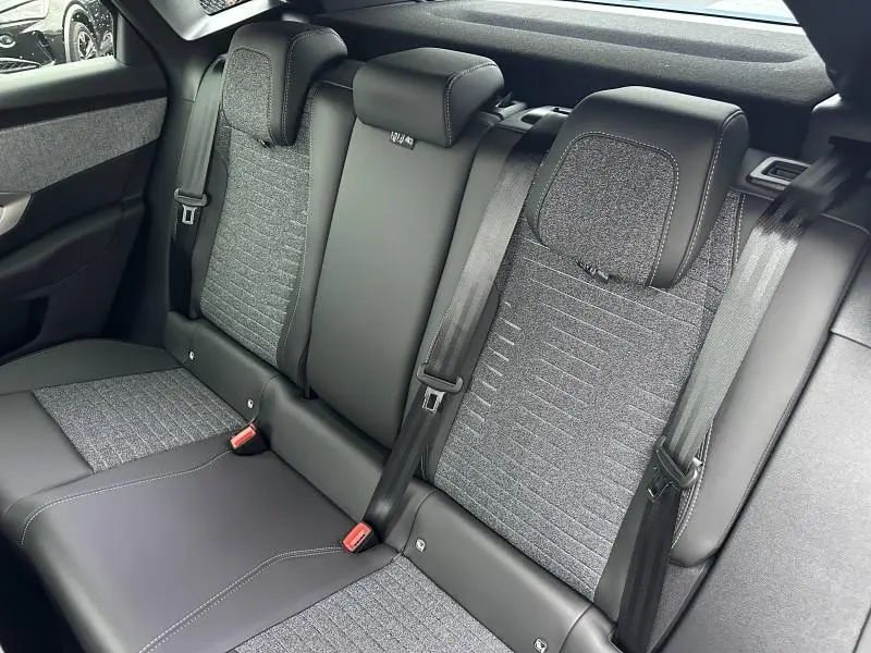 Banquette arrière en tissu gris et cuir noir du Peugeot 3008 hybride 2025, vue latérale côté droit.