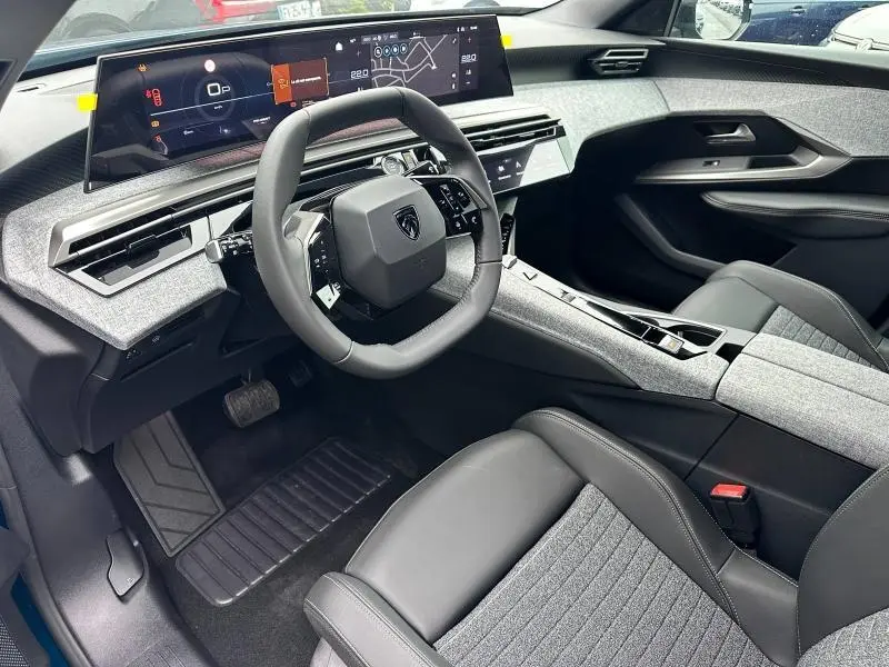 Intérieur du Peugeot 3008 Hybrid 2025 vu côté conducteur, avec volant compact et tableau de bord numérique large.