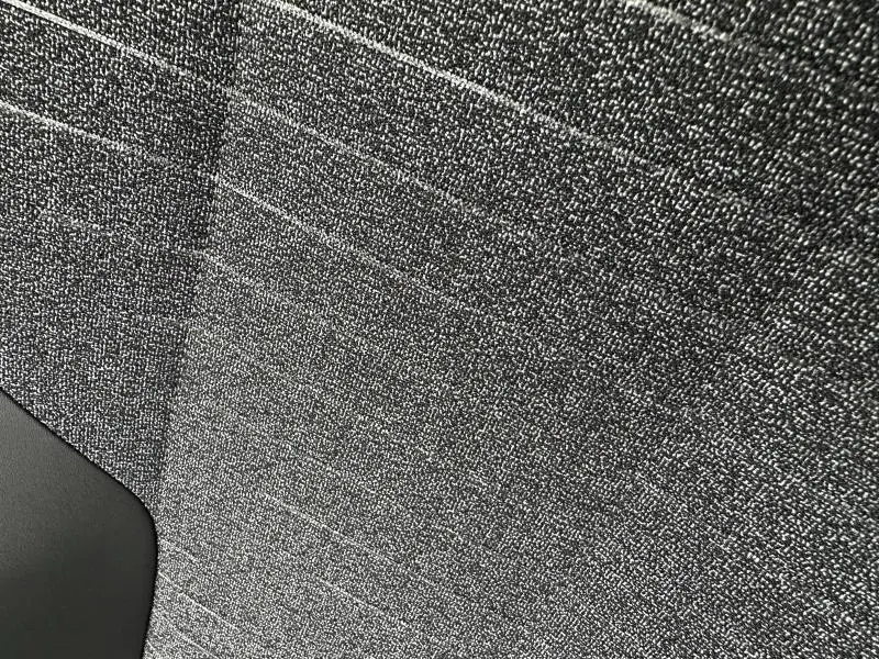 Gros plan sur le tissu CRISPY gris texturé de la banquette arrière du Peugeot 3008 Hybrid 2025.