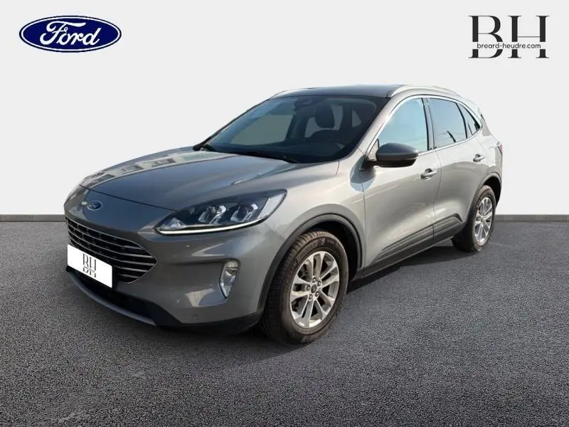 Ford Kuga gris Solar métallisé vu en 3/4 avant droit avec calandre large et jantes alliage.