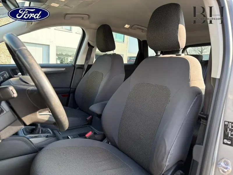 Vue intérieure côté avant droit du Ford Kuga 2.0 EcoBlue 2020 avec sièges tissu noir et volant cuir multifonction.