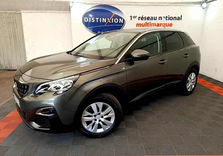 Peugeot 3008 gris foncé vue 3/4 avant droit, avec phares LED et jantes alliage en showroom.