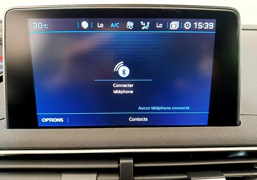 Écran tactile central du tableau de bord du Peugeot 3008 gris foncé, affichant la connexion Bluetooth au téléphone.