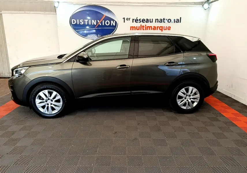 Peugeot 3008 gris foncé vue de profil côté gauche dans un showroom avec sol à damiers gris et rouge.