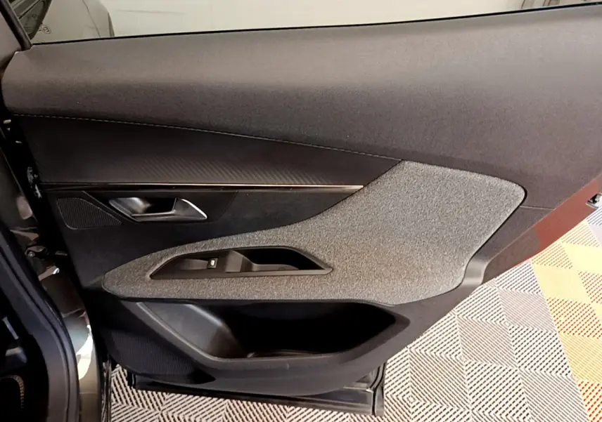 Vue rapprochée de la porte côté gauche du Peugeot 3008 gris foncé, avec garniture tissu et commandes de fenêtre intégrées.