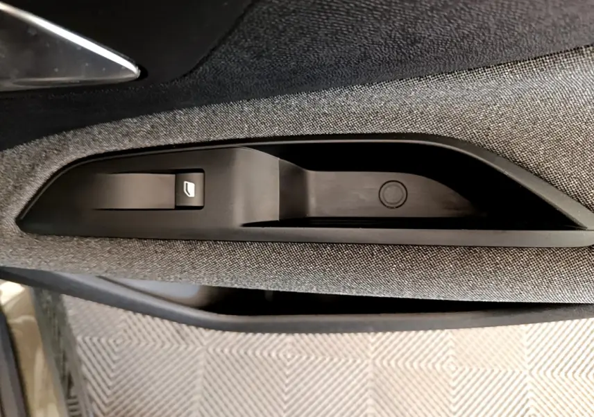 Détail de la commande de lève-vitre sur la porte côté gauche d’un Peugeot 3008 gris foncé 2020.