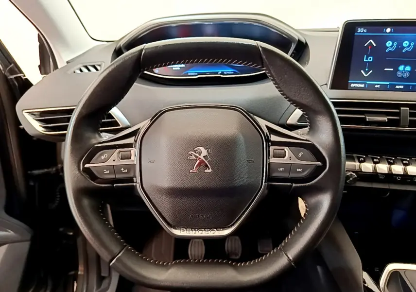 Vue rapprochée du volant cuir multifonctions et du tableau de bord numérique du Peugeot 3008 gris foncé de 2020.