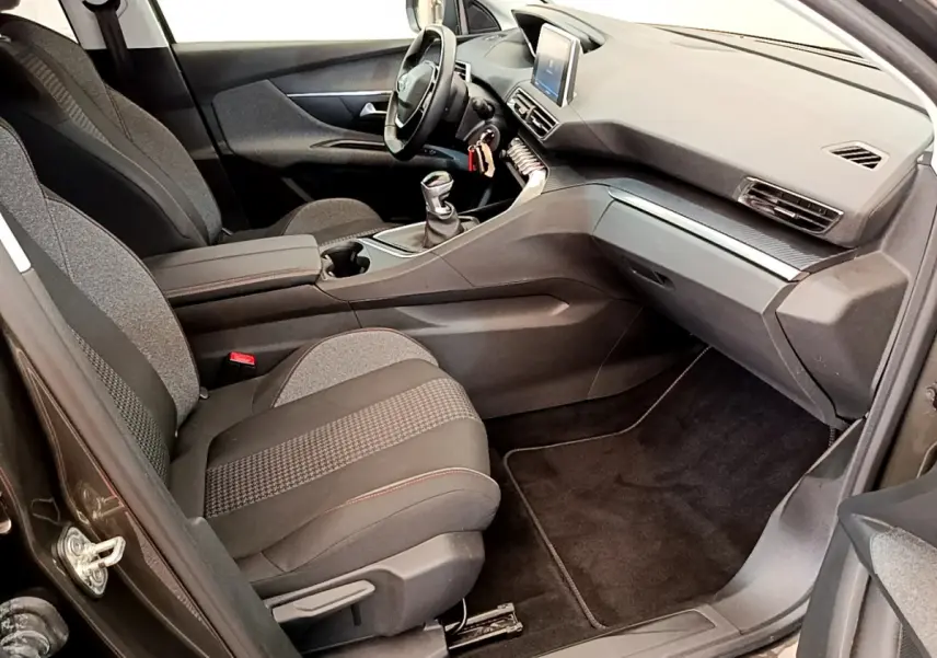 Intérieur avant droit du Peugeot 3008 gris foncé 2020 avec tableau de bord moderne et volant cuir multifonctions.