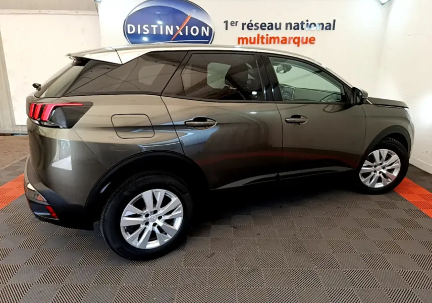 Peugeot 3008 gris foncé vue de profil côté droit, avec feux arrière à trois griffes rouges et jantes argentées.
