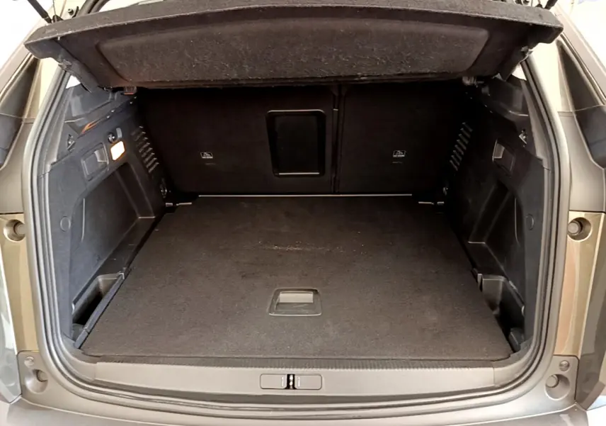 Coffre ouvert du Peugeot 3008 gris foncé, vue arrière montrant l'espace de chargement et la banquette rabattue.