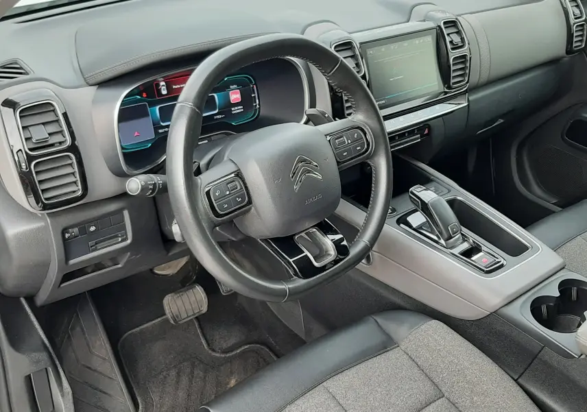 Vue intérieure côté conducteur du Citroën C5 Aircross 2020, tableau de bord noir avec écran tactile et volant multifonction.
