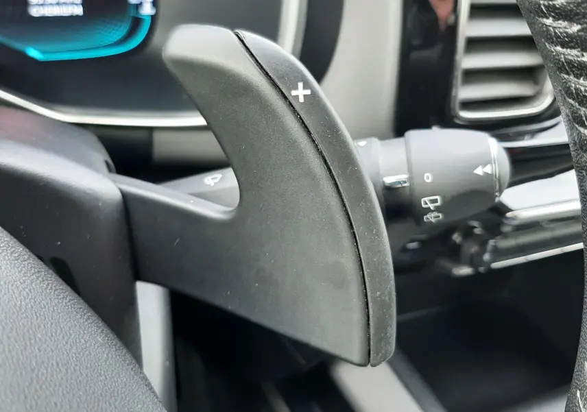 Gros plan sur la palette de changement de vitesse droite (+) du volant d'une Citroën C5 Aircross blanc, intérieur gris.